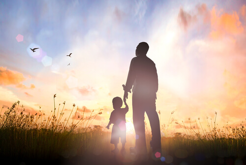 father and child watch sunset