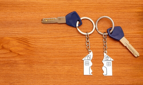 marital property or community property division during divorce symbolized by two house keys and a broken home
