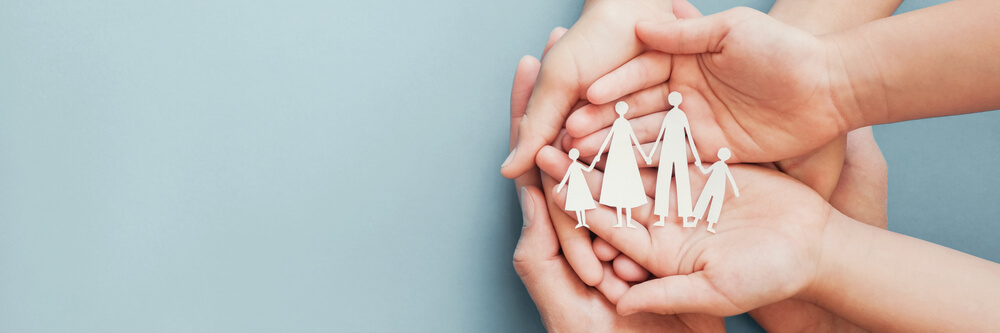 Hands holding paper family of four