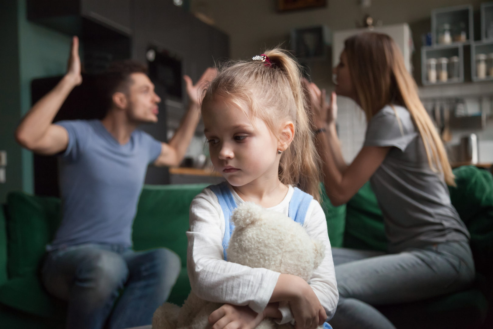 Kid daughter feels upset while parents fighting at background