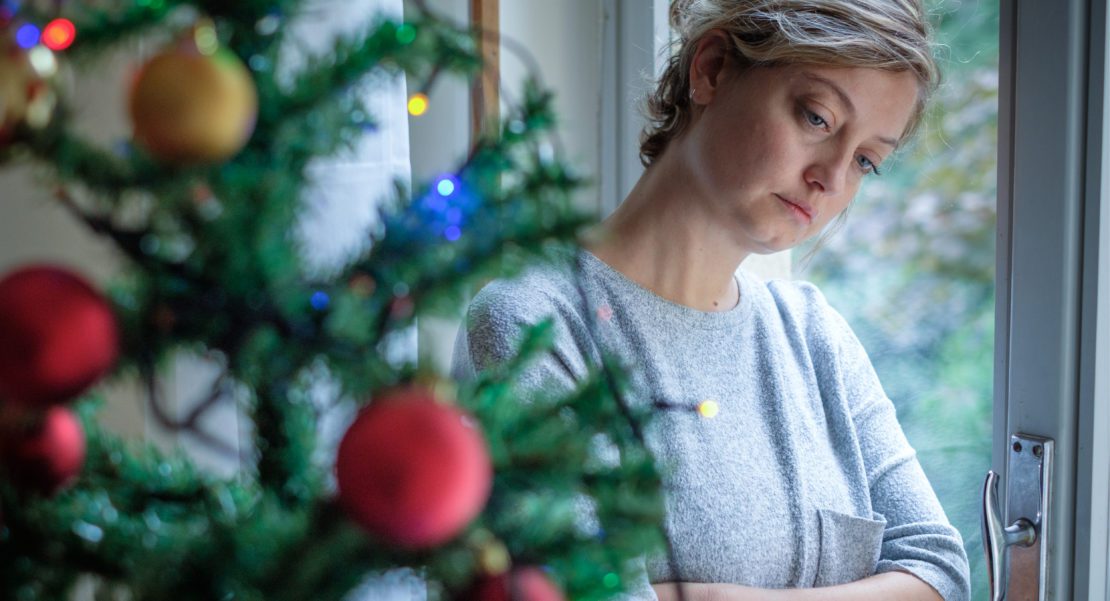 Divorced Woman Looking at Christmas Tree