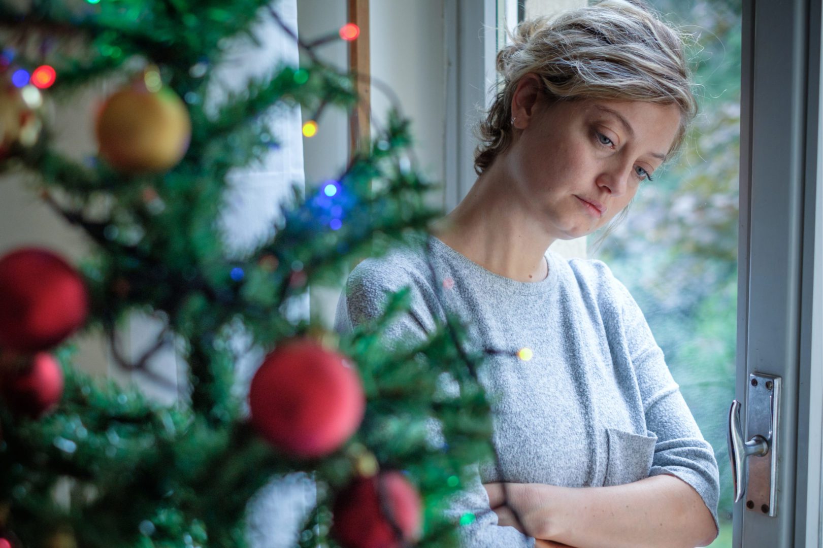 Divorced Woman Looking at Christmas Tree